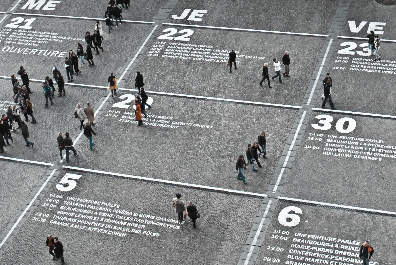 People walking over giant ground calendar