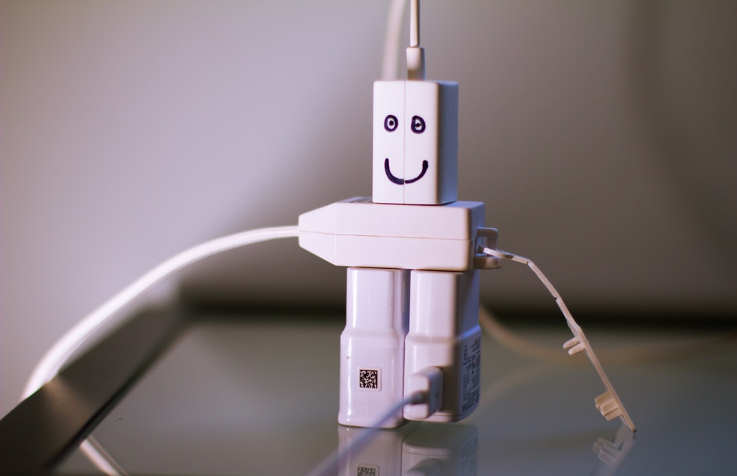 A robot made of power adapters with smiley face