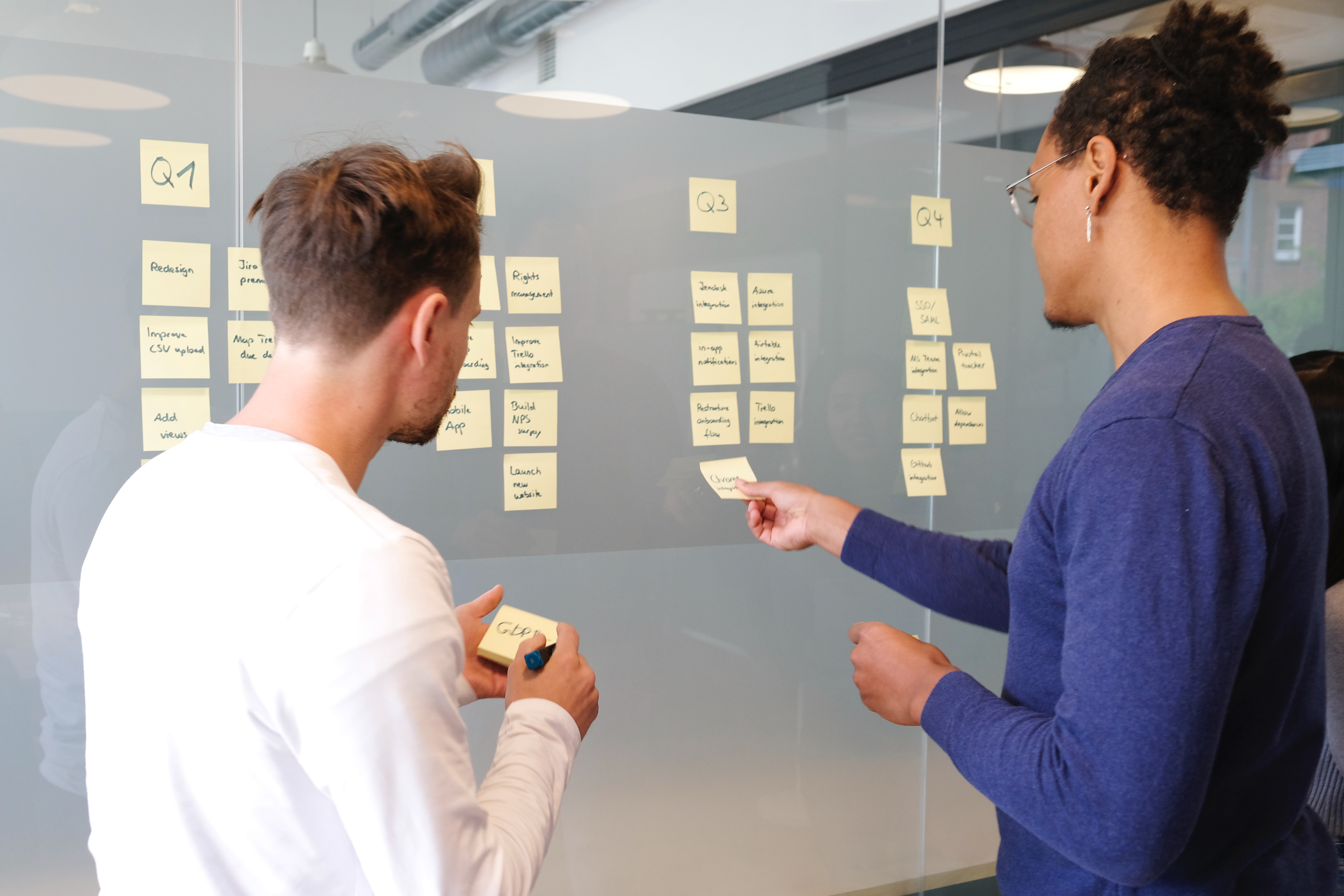 Two people are planning the project with sticky notes