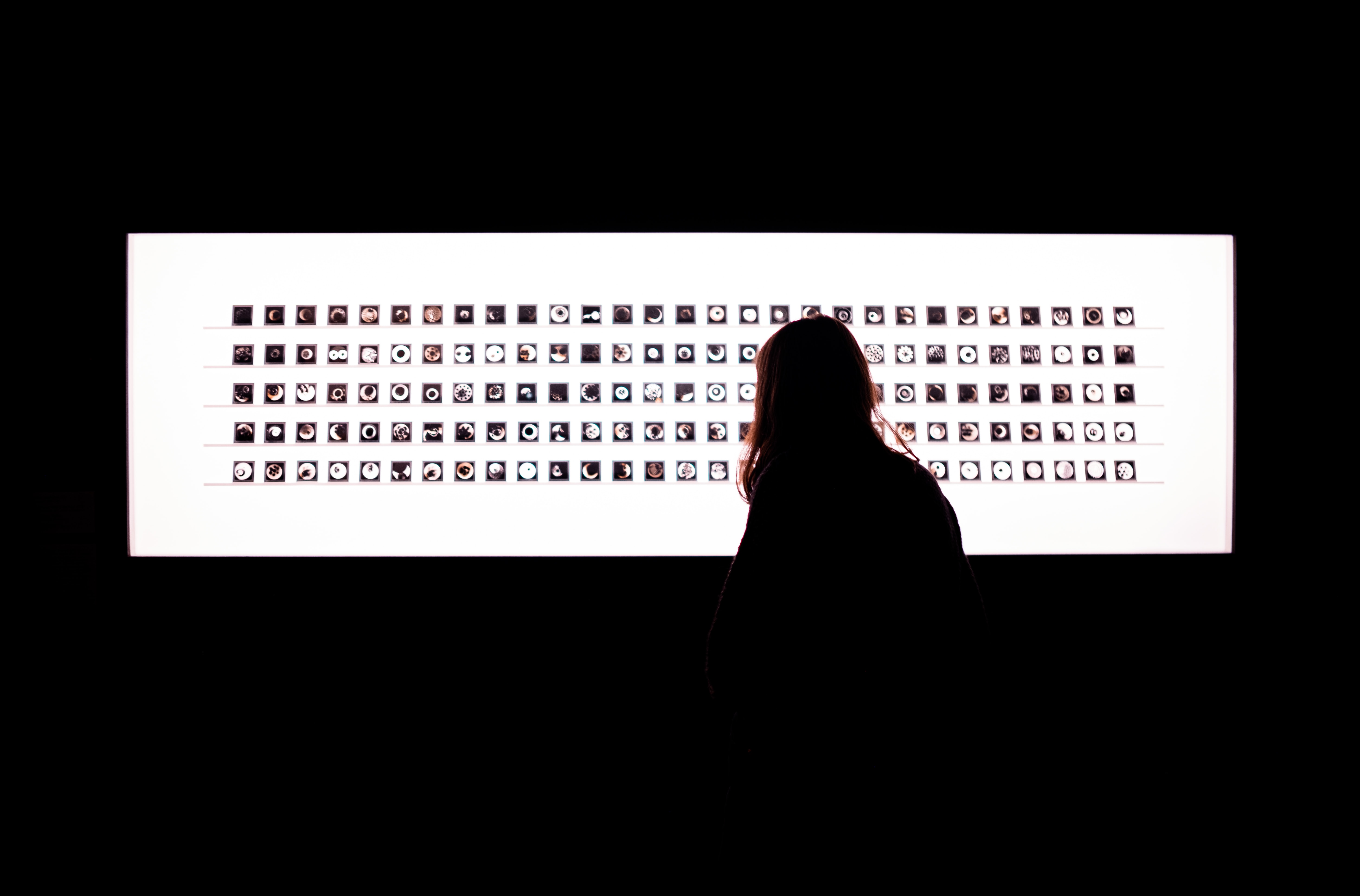 A person is looking at a light box filled with pictures