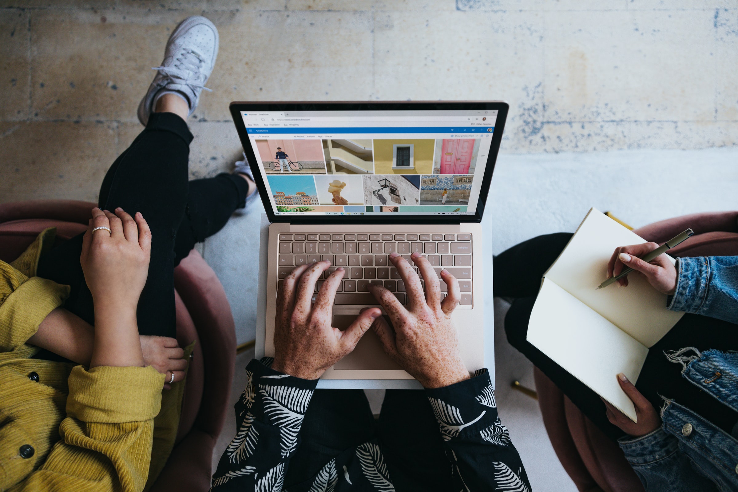 Three people looking at the photos on the laptop