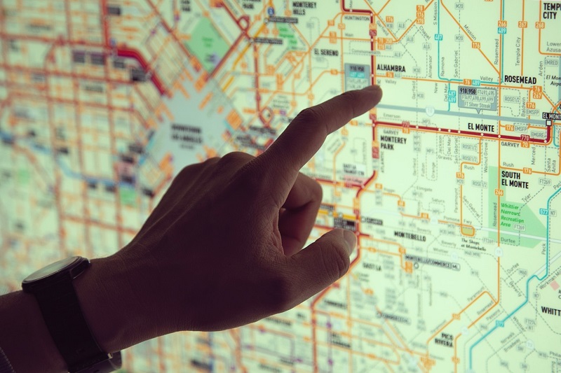 A hand pointing on a city's public transport map