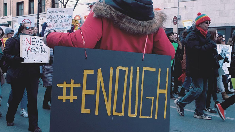 Protestor with #enough sign