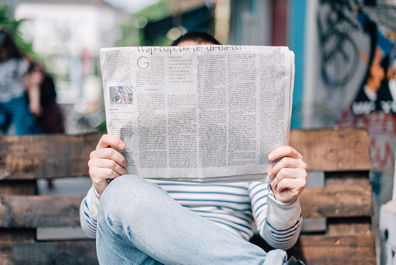 Reading newspaper on the street