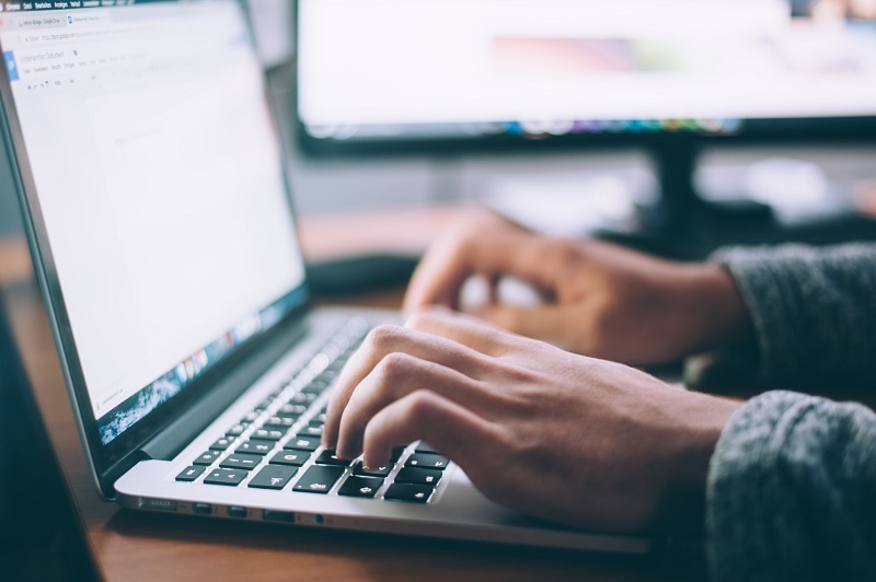 person working on a blog article on their laptop