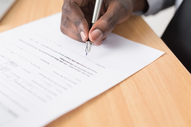 a hand signing an important document